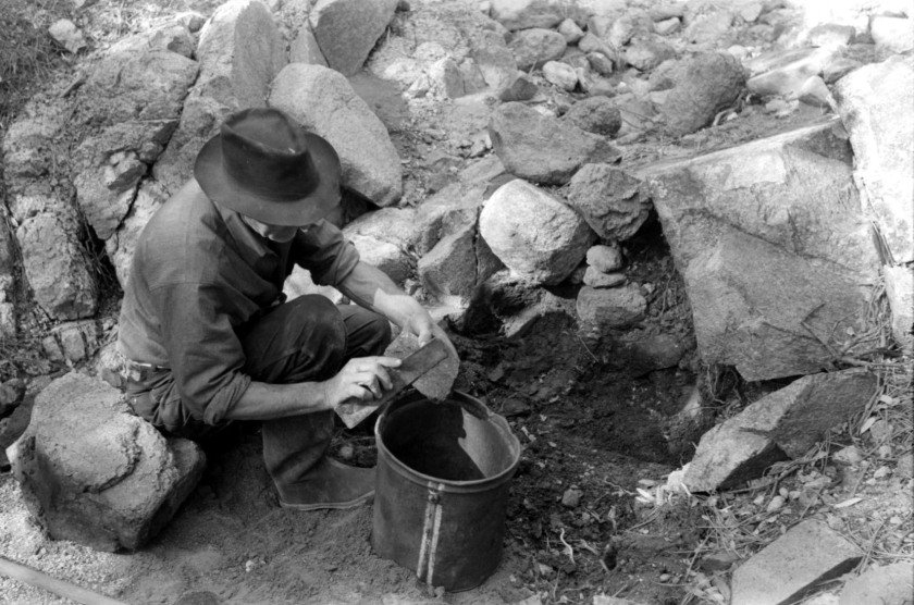 Prospector taking a sample of dirt from a creek bed_01